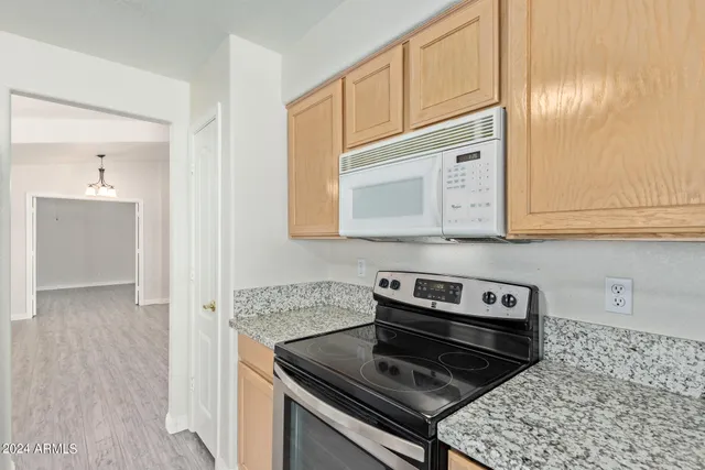 a kitchen with granite countertop cabinets stove top oven and microwave