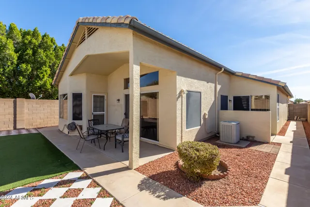 a backyard of a house with table and chairs