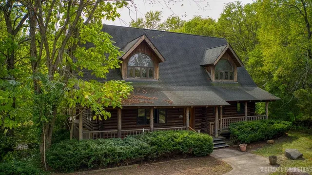 a front view of a house with a yard and trees