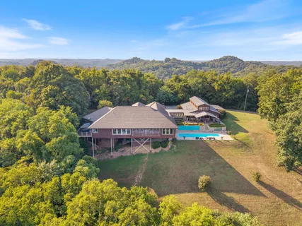 a view of a house with a yard and lake view