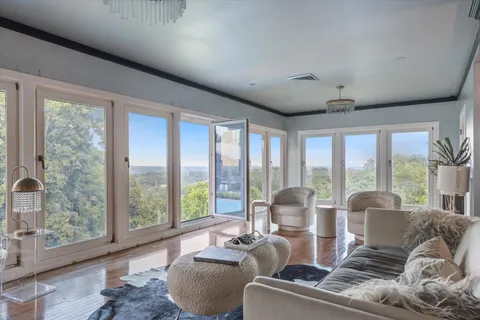 a living room with furniture and floor to ceiling windows