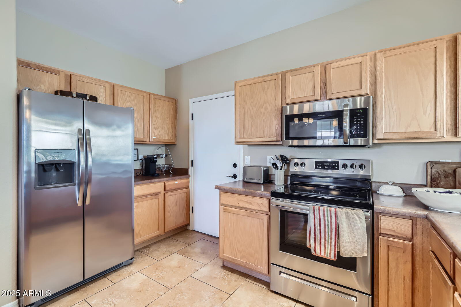 2801 North Litchfield Road, Unit 65 Goodyear, AZ 85395 - Photo 11 of 30 a kitchen with stainless steel appliances granite countertop a refrigerator stove microwave and sink