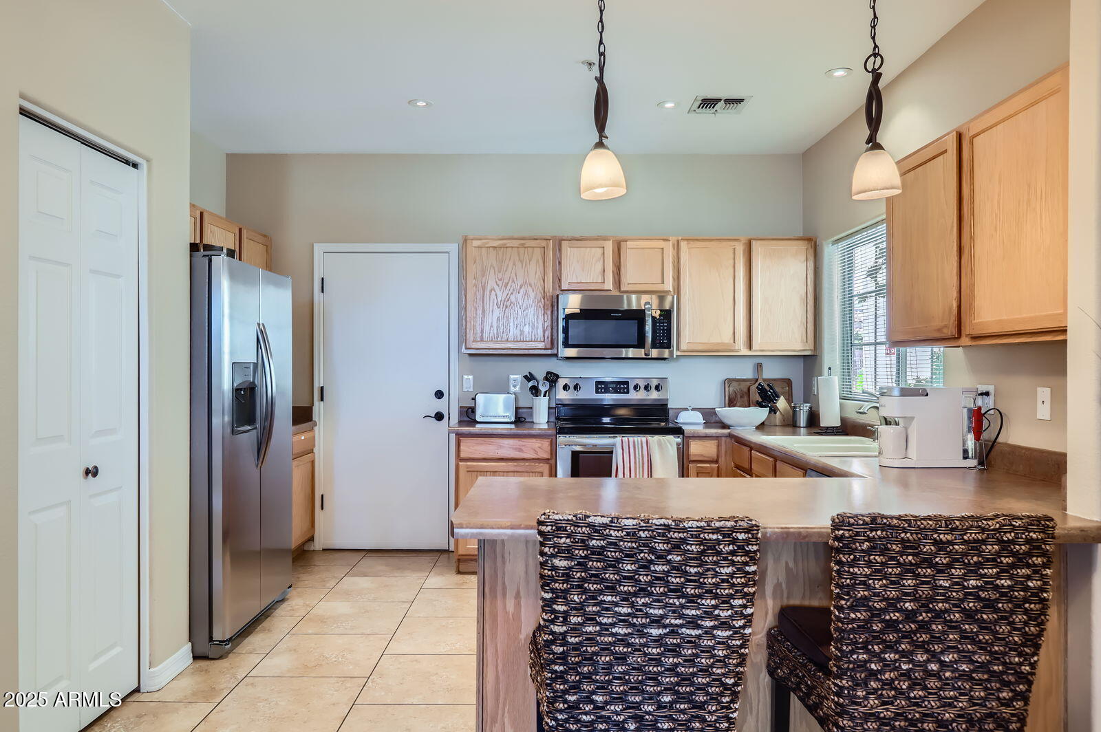 2801 North Litchfield Road, Unit 65 Goodyear, AZ 85395 - Photo 13 of 30 a kitchen with stainless steel appliances granite countertop a refrigerator a sink a stove a microwave and wooden cabinets