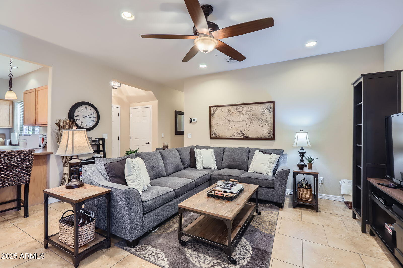 2801 North Litchfield Road, Unit 65 Goodyear, AZ 85395 - Photo 3 of 30 a living room with furniture a clock and a flat screen tv