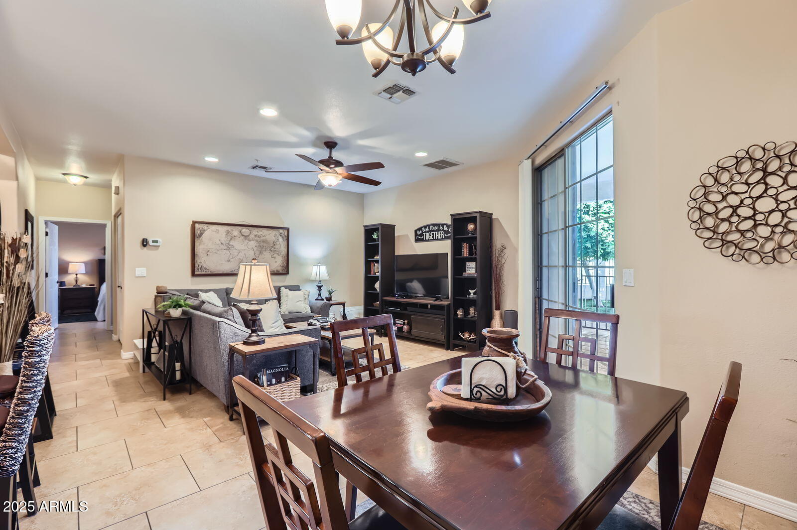2801 North Litchfield Road, Unit 65 Goodyear, AZ 85395 - Photo 7 of 30 a living room with furniture a chandelier and a flat screen tv