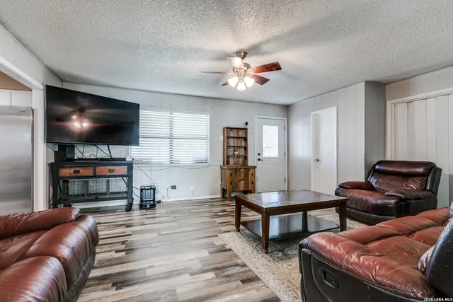 a living room with furniture and a wooden floor
