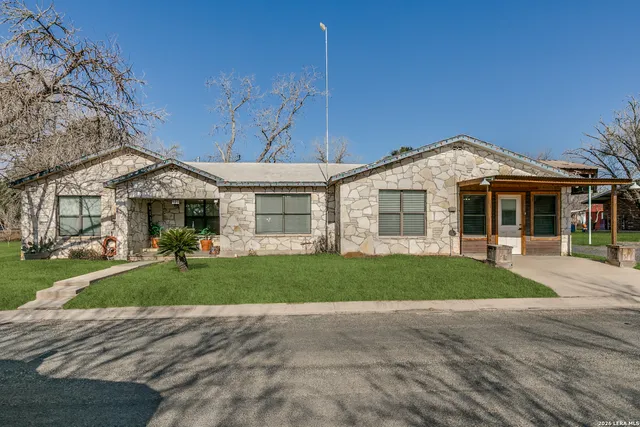 a front view of a house with a yard and outdoor seating