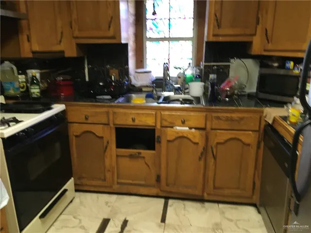 a kitchen with stainless steel appliances granite countertop a stove a sink and a microwave