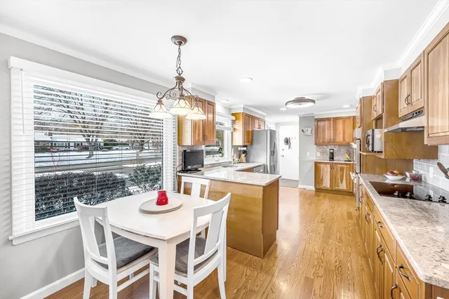 a dining room with stainless steel appliances kitchen island granite countertop a dining table chairs and a living room view