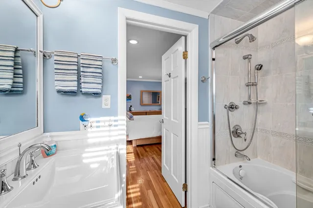 a bathroom with a tub sink and mirror