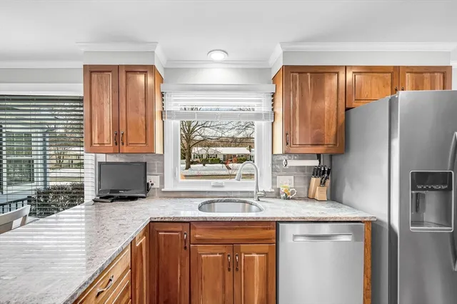 a kitchen with stainless steel appliances granite countertop a refrigerator and a sink