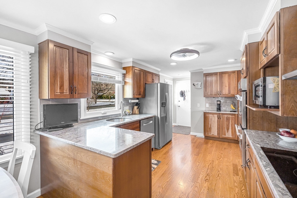 361 Frank Smith Road Longmeadow, MA 01106 - Photo 5 of 42 a kitchen with stainless steel appliances granite countertop a refrigerator a sink dishwasher a stove and white countertops with wooden floor