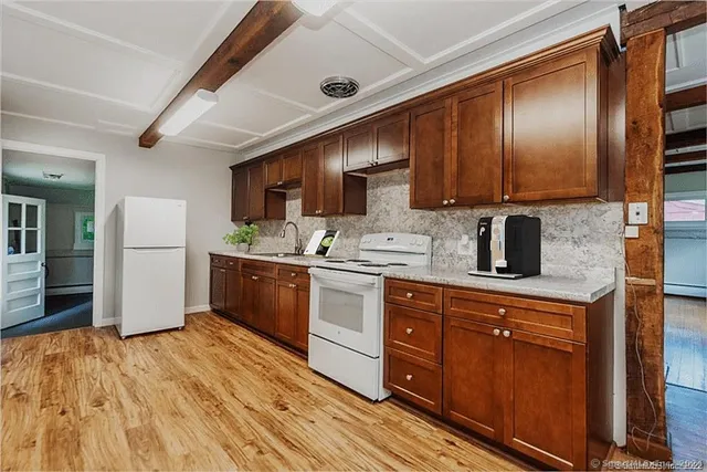 a kitchen with stainless steel appliances granite countertop wooden cabinets a refrigerator and a sink