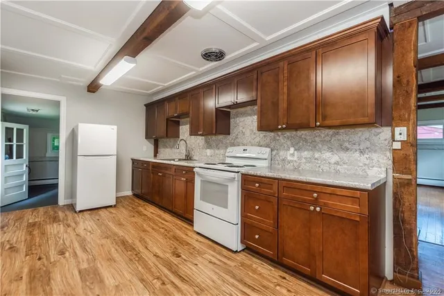 a kitchen with stainless steel appliances granite countertop wooden cabinets a refrigerator and a sink