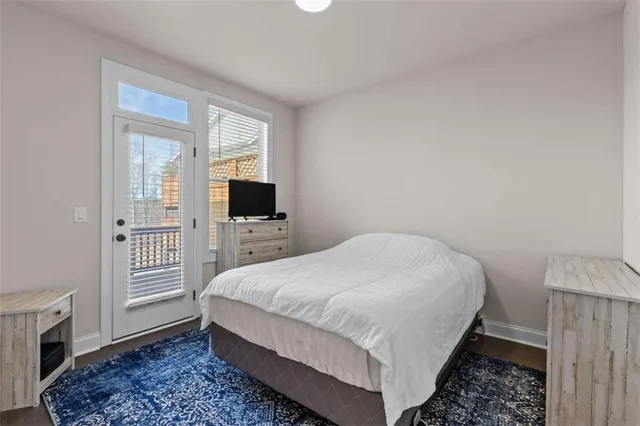 a bedroom with a bed table and flat screen tv