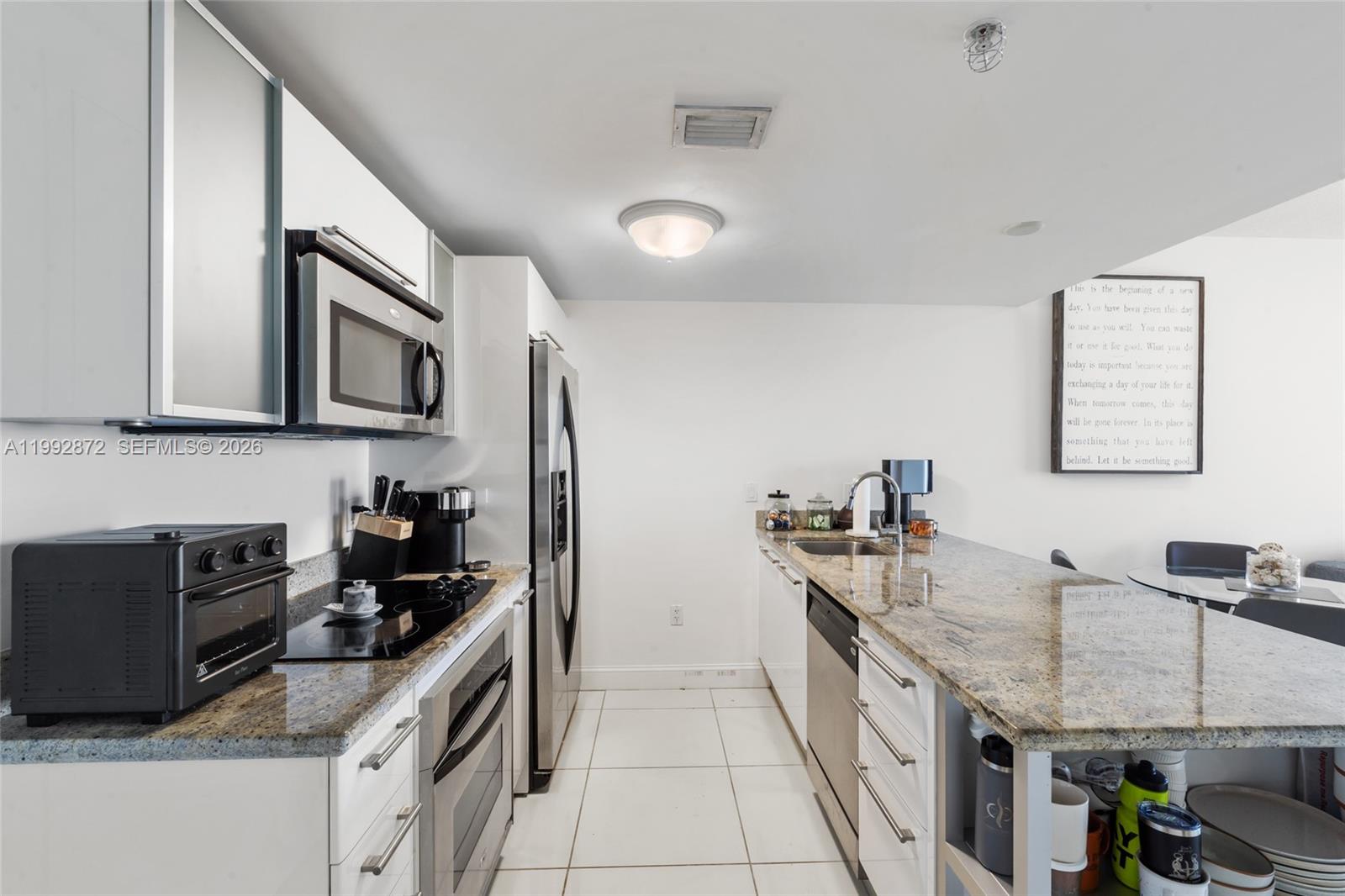 185 Southwest 7th Street, Unit 3414 Miami, FL 33130 - Photo 12 of 32 a kitchen with stainless steel appliances granite countertop a sink stove and refrigerator