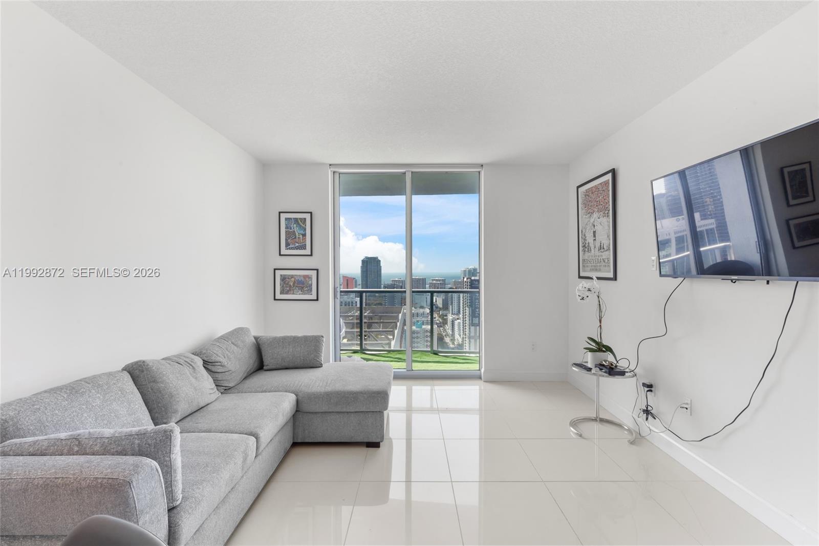 185 Southwest 7th Street, Unit 3414 Miami, FL 33130 - Photo 20 of 32 a living room with furniture and a floor to ceiling window