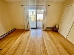 a view of a room with wooden floor and door