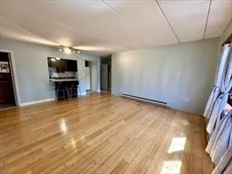 a view of empty room with a fireplace and wooden floor