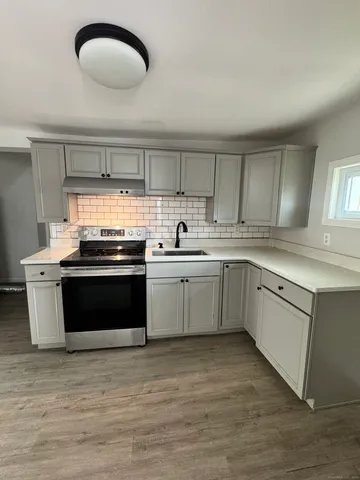 a kitchen with a sink stove and cabinets