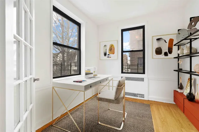 a view of a workspace with furniture and a window