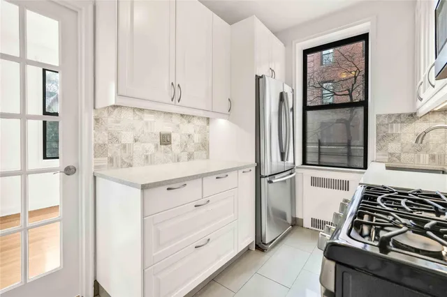 a kitchen with white cabinets and appliances