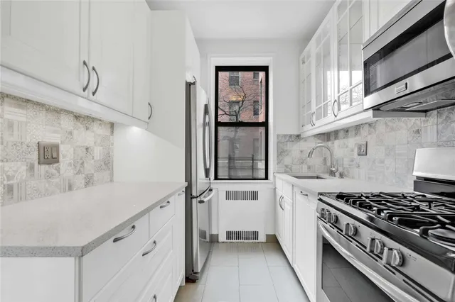 a kitchen with granite countertop cabinets and stove top oven