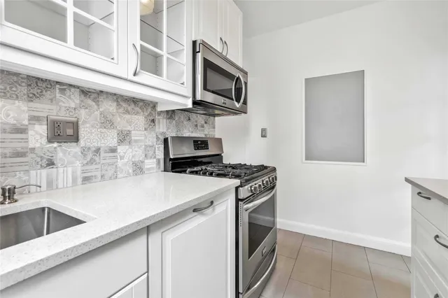 a kitchen with stainless steel appliances a stove microwave and sink
