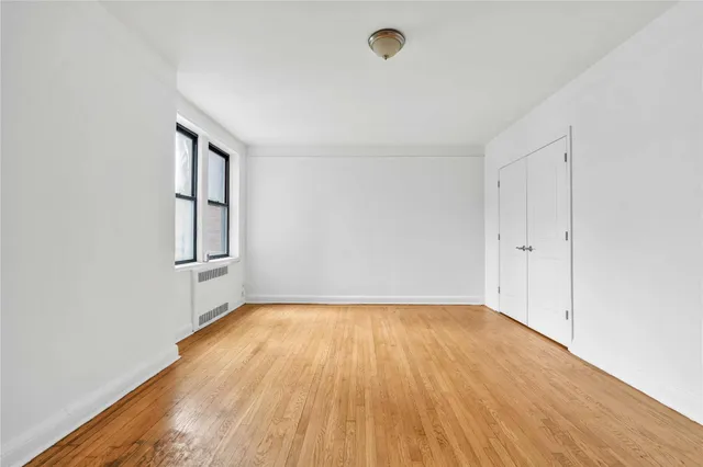a view of a room with wooden floor and white walls