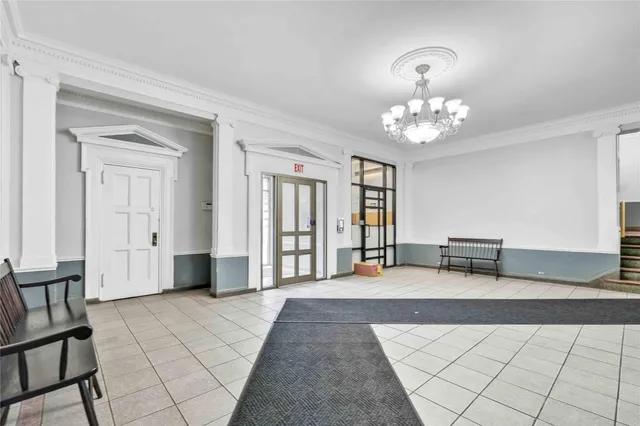 a spacious bedroom with a bed and a chandelier