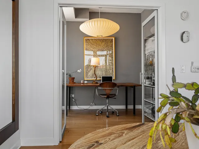 a view of a workspace with furniture and a window