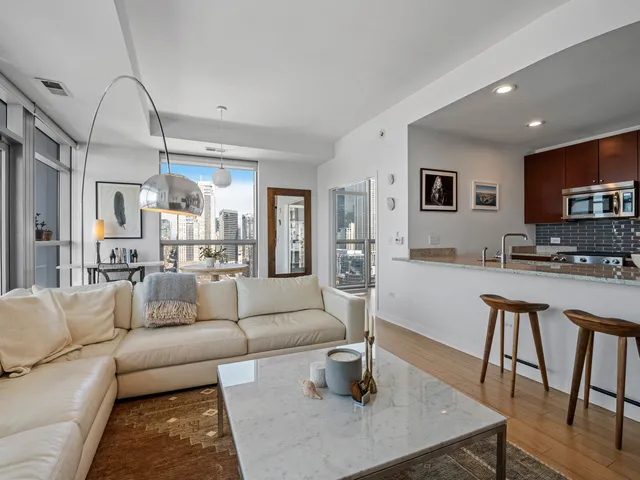 a living room with furniture and a dining table with wooden floor