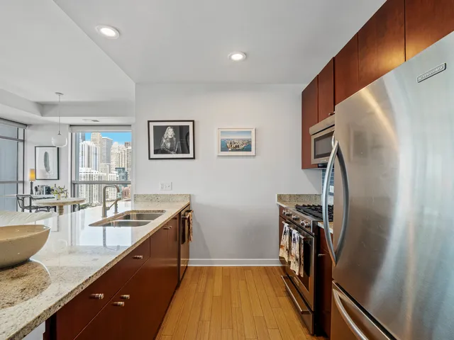 a kitchen with granite countertop a refrigerator stove and sink