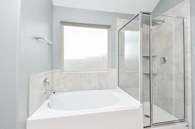 a white bath tub sitting next to a shower