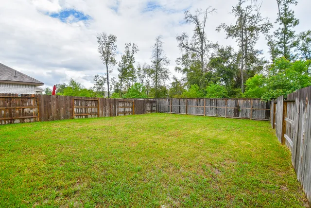 a front view of a house with a yard and potted plants