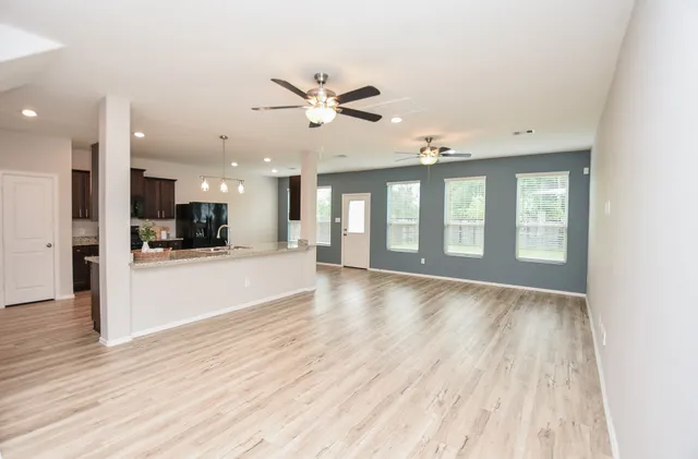 a view of an empty room and kitchen view