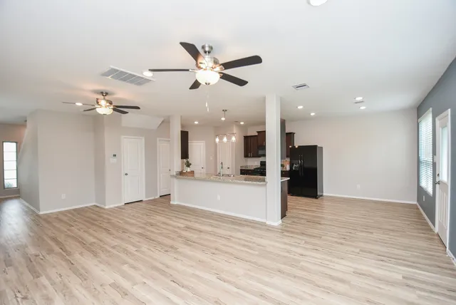 an empty room with wooden floor and windows