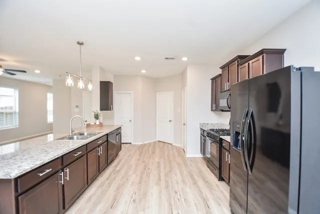 a large kitchen with kitchen island a sink stainless steel appliances and cabinets