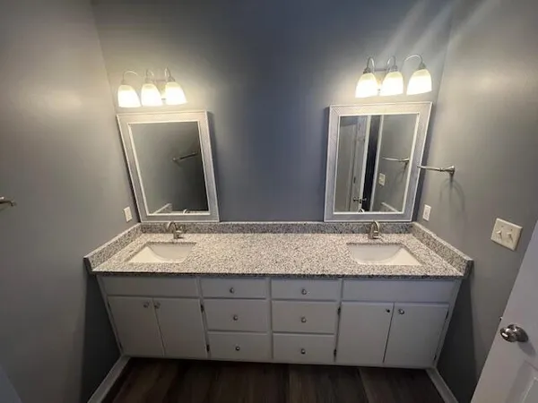 a bathroom with double sink and a mirror