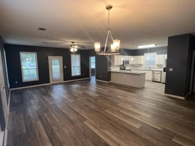 a view of a kitchen with refrigerator microwave and wooden floor