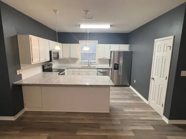 a kitchen with stainless steel appliances granite countertop a refrigerator sink and cabinets