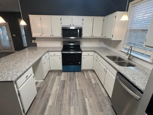 a kitchen with granite countertop a sink a stove and cabinets