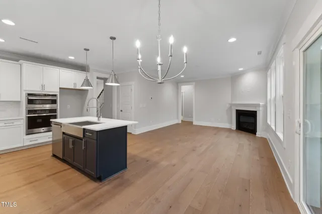 a kitchen with stainless steel appliances granite countertop a stove and a wooden floors