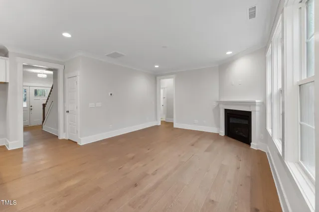 a view of empty room with wooden floor and fireplace