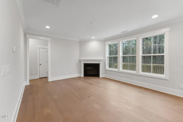an empty room with a fireplace and windows