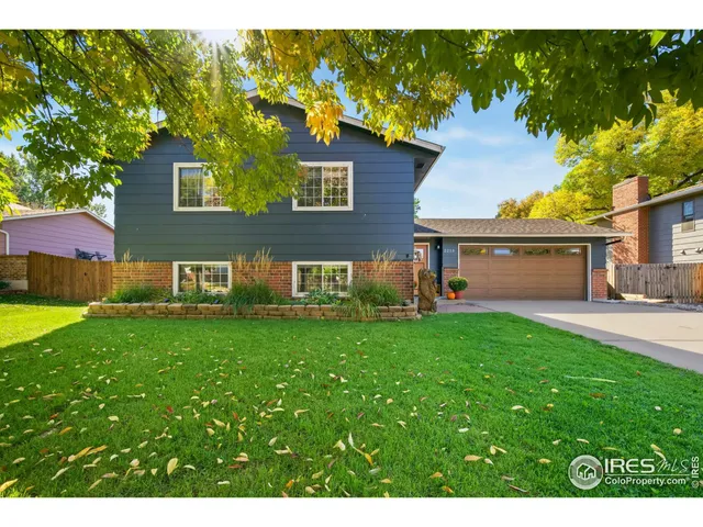a view of a house with backyard and a tree
