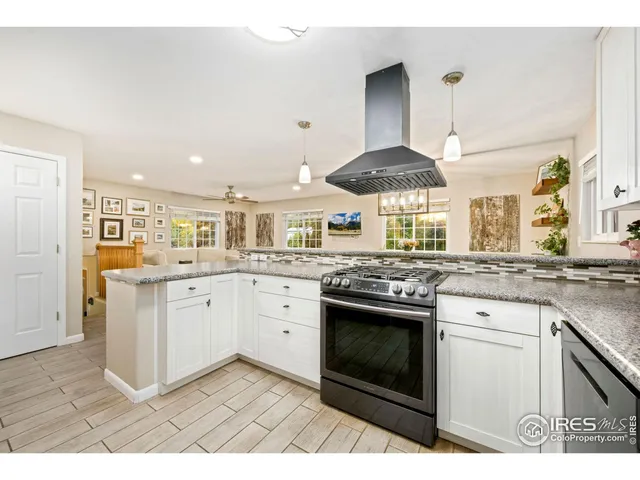 a kitchen with granite countertop white cabinets and stainless steel appliances