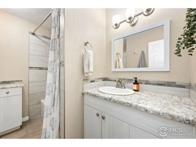 a bedroom with a bed a dresser and next to a window