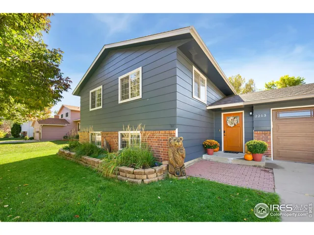 a front view of a house with garden and chairs