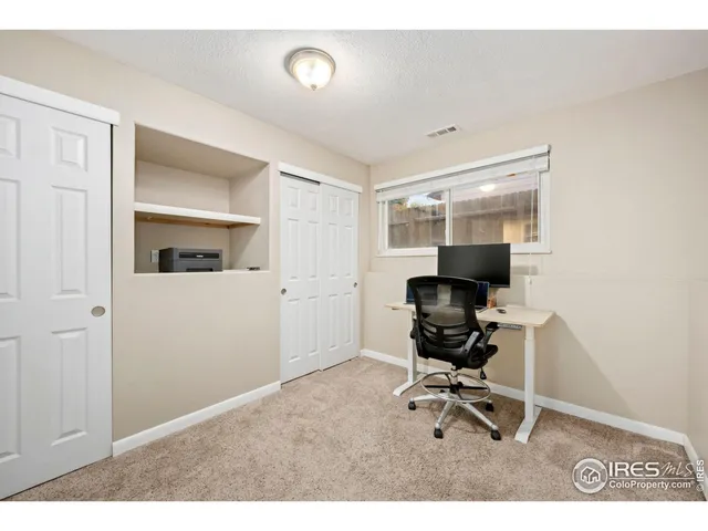 a living room with furniture a book shelf and a window